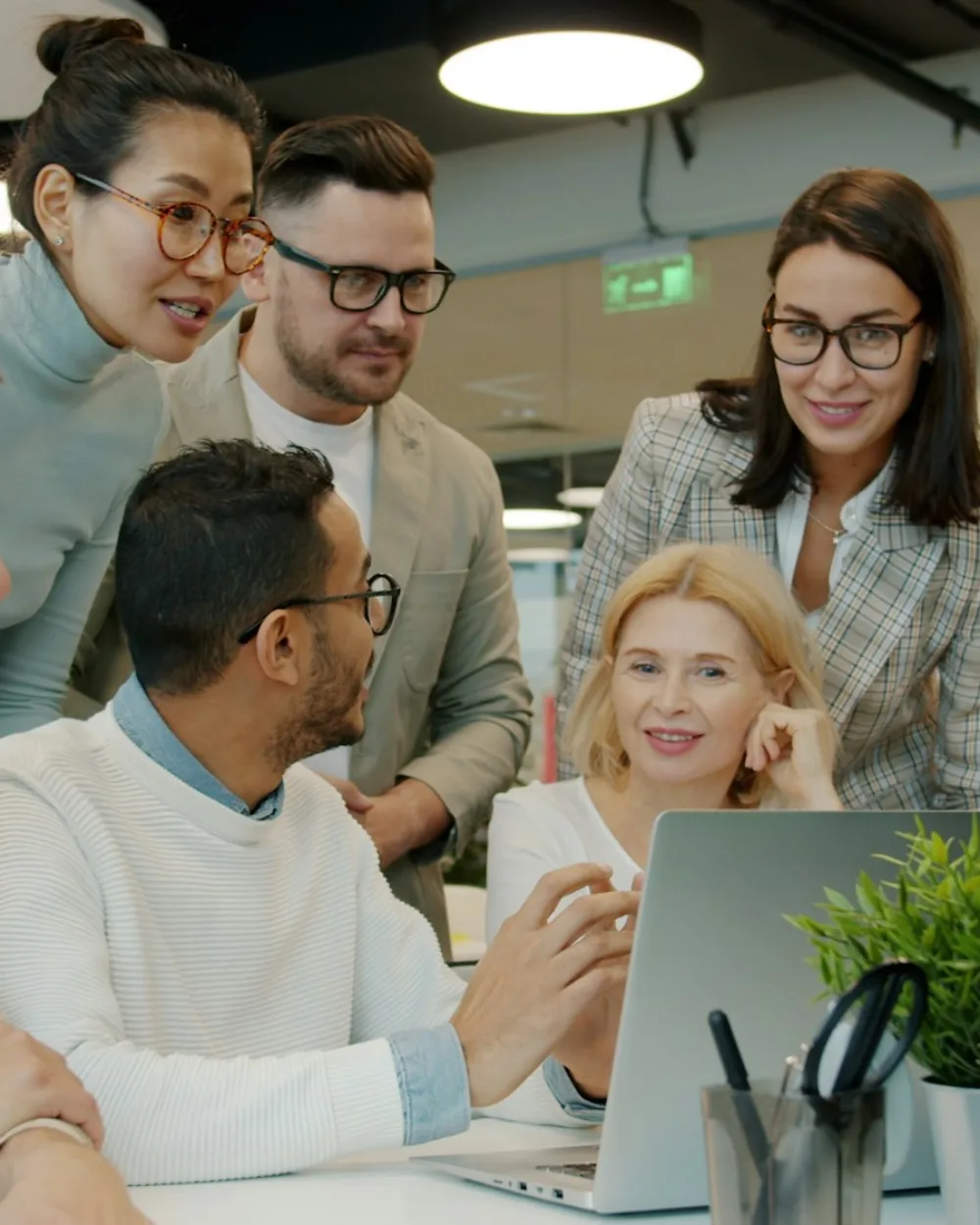A marketing team working together around a laptop